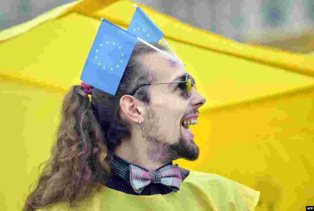 An activist of the Ukrainian movement "For A European Future" smiles as he places EU flags on his forehead during a rally on Independence Square in Kyiv on October 30. (AFP/Sergei Supinsky)