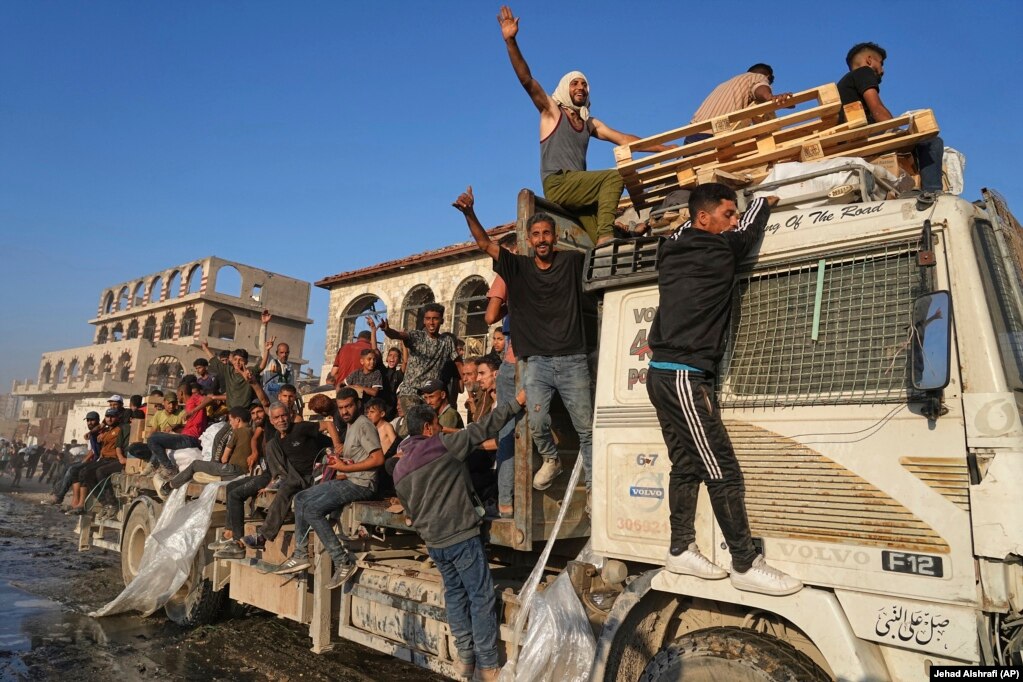 Palestinezë duke udhëtuar me një kamion që u solli ndihma.