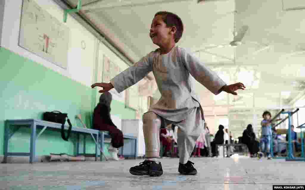 Ahmad Sayed Rahman, a five-year-old Afghan boy who lost his right leg when he was hit by a bullet in the crossfire of a battle, dances with his prosthetic leg at the International Committee of the Red Cross hospital for war victims and the disabled, in Kabul on May 7. (AFP/Wakil Kohsar)