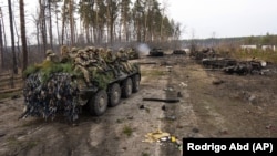 Украинские солдаты возле разбитой российской военной техники под Киевом (архивное фото)