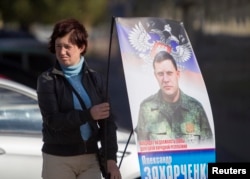 Донецк - женщина с плакатом, агитирующим голосовать за Александра Захарченко