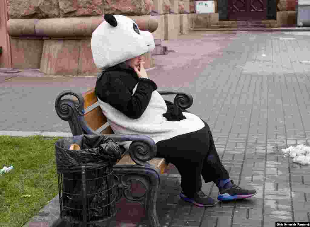 A man dressed as a panda rests between posing for pictures with tourists in central Kyiv. (Reuters/Gleb Garanich)