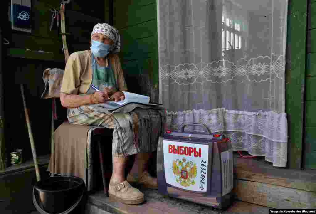 A local resident fills in documents near a mobile ballot box outside her house during a seven-day vote on constitutional reforms in the village of Troitskoye in the Moscow region on June 25. (Reuters/Evgenia Novozhenina)