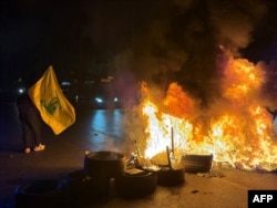 Pristalice Hezbolaha blokiraju stari put do aerodroma u južnim predgrađima Bejruta, paleći gume, iz protesta protiv sporazuma koji su potpisale SAD, Izrael i Liban 27. juna.
