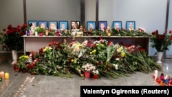 Фото членів екіпажу літака «Міжнародних авіалінії України» «Боїнг 737-800», який зазнав катастрофи в Ірані, вшановують загиблих в міжнародному аеропорту «Бориспіль» біля Києва, 8 січня 2020 року