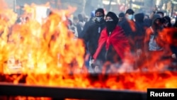 Demonstranti blizu kontejnera za smeće koji gore, tokom antivladinog studentskog protesta u Tirani, u Albaniji, 17. oktobra 2026.