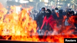 Protestues mblidhen pranë koshave të plehrave që digjen, gjatë protestës antiqeveritare të studentëve në Tiranë, Shqipëri, më 17 tetor 2026.