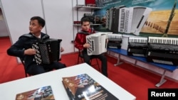 Așa da! Participanți la o expoziție oficială nord-coreeană la Vladivostok, în Extremul Orient al Rusiei, intrepretând melodii populare la acordeon, pe 26 iunie 2024. 