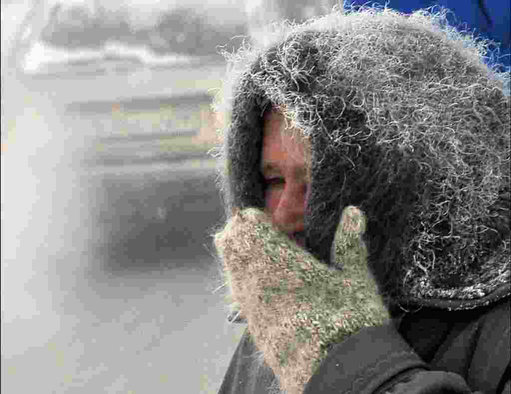 An elderly woman shields her face against the abnormally cold temperatures in the northeastern Kazakh city of Pavlodar, where temperatures reached minus 37 degrees Celsius. (AFP/Vladimir Bugayev)