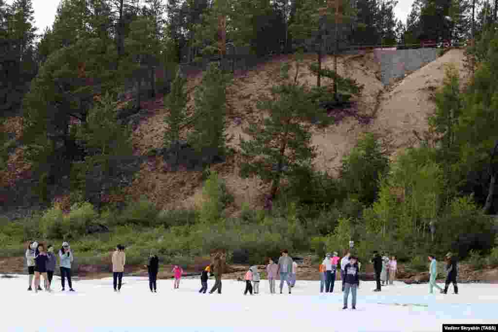 Туристи се разхождат и се снимат по повърхността на ледника.