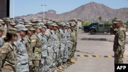 Membri ai Gărzii Naționale din Arizona ascultă instrucțiuni, la Rezervația militară Papago Park din Phoenix. 9 aprilie 2018. În timpul primului mandat, Donald Trump a ordonat combaterea traficul de droguri și imigrația ilegală.