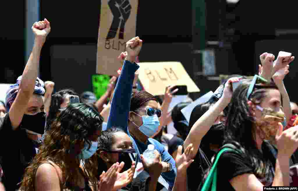 Люди со сжатыми кулаками призывают к справедливости в отношении убитых во время задержания полицейскими. Лос-Анджелес, 8 июня