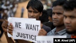 Refugjatët rohingya mbajnë pankarta në duar ku shkruhet "Duam drejtësi".