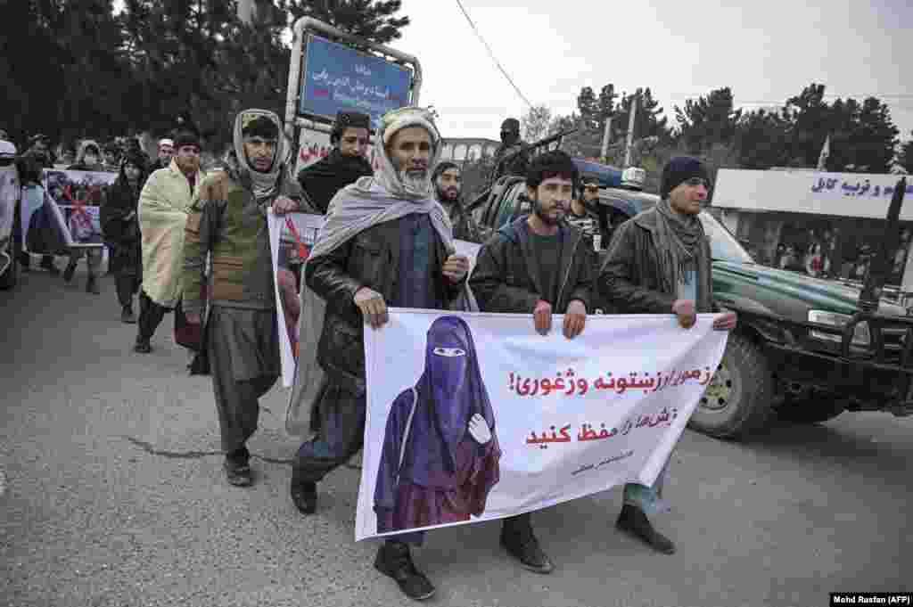 After: Afghan men, carrying a banner that says "Save our values," protest against women's rights activists in Kabul in January 2022. 