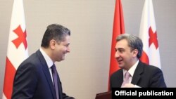 Georgia - Prime Minister Nika Gilauri (R) and his Armenian counterpart Tigran Sarkisian exchange copies of a memorandum signed after talks in Batumi, 19Nov2011.