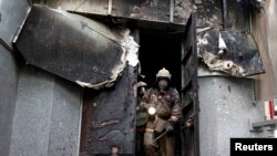 Firefighters inspect the burnt-out police headquarters in Mariupol.