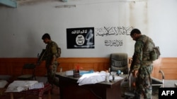 FILE: Afghan security forces inspect an Islamic State (IS) hideout in Kot District of the eastern Nangarhar province in July.