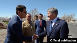 Балыкчы шаарынын мэри Алмазбек Мамбетов "Балыкчы-Корумду" жолу менен таанышуу учурунда президент Алмазбек Атамбаев менен учурашууда.