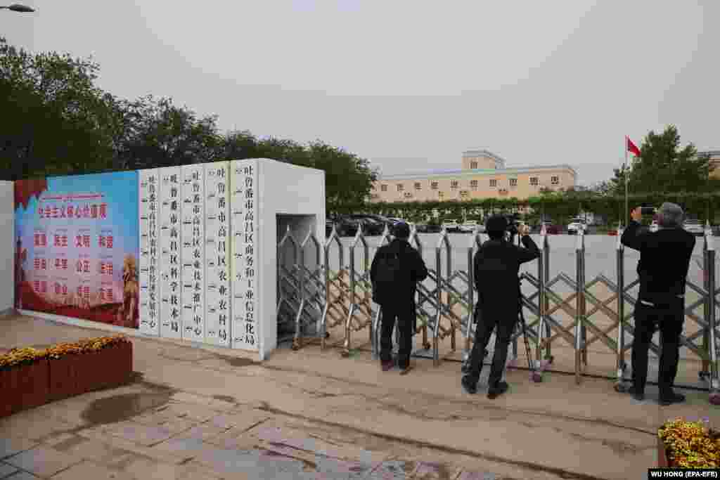 CHINA XINJIANG -- Foreign journalists take photos and video outside a location that that was identified in early 2020 as a re-education facility by an Australian think tank, and which the Chinese government asserts is currently home to a veterans' affairs