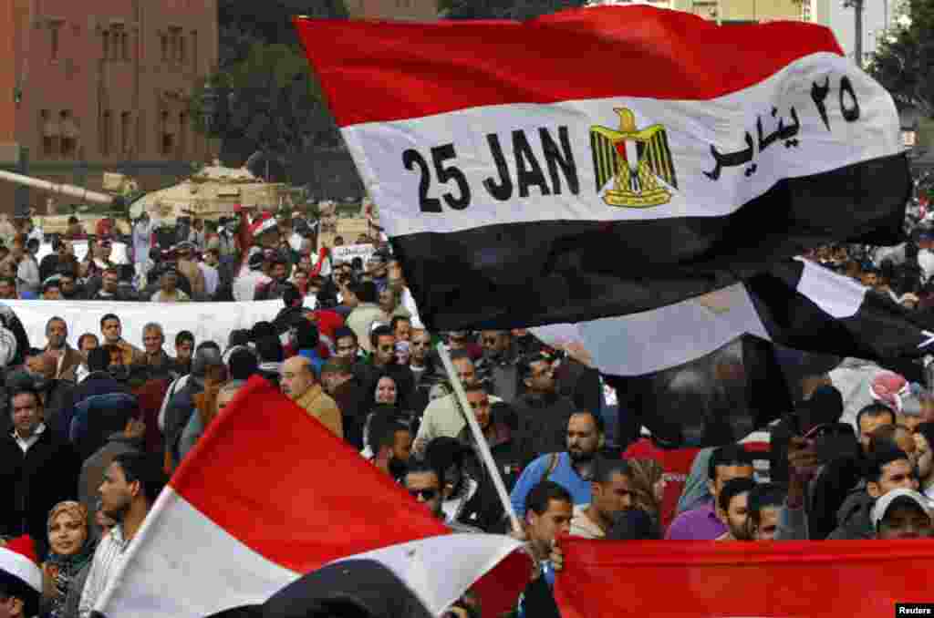 An Egyptian flag with January 25 -- the date the uprising started -- written on it is seen amid the crowd near army tanks on Tahrir Square on February 11, 2011.