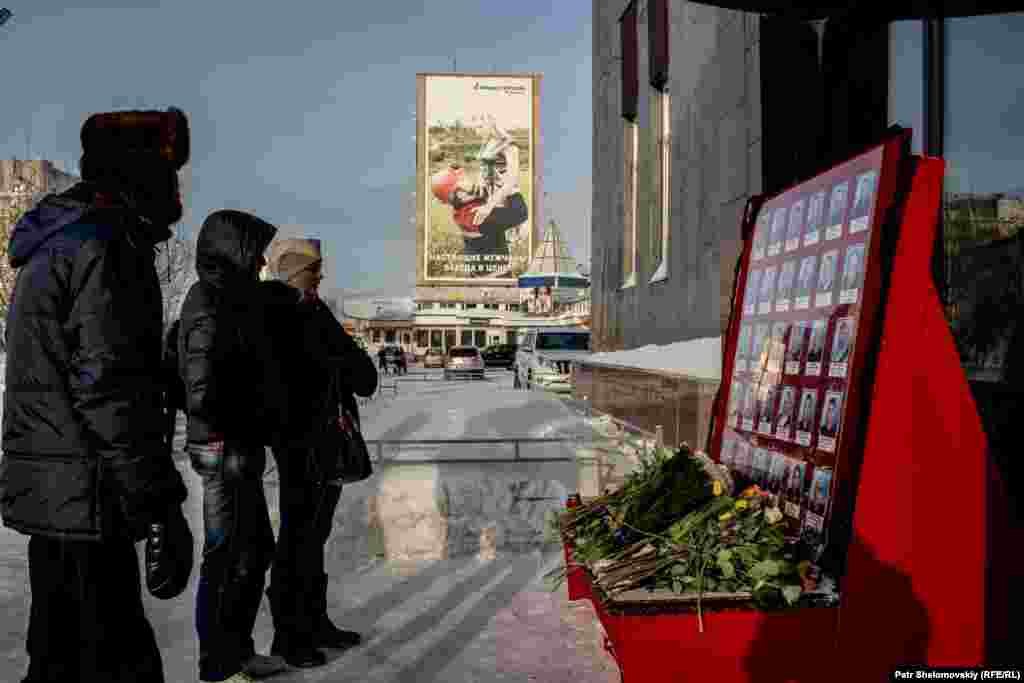 Vorkuta locals stand in front of an impromptu memorial for victims of the Severnaya coal mine explosion, near the entrance to the Vorkutaugol mining company office.