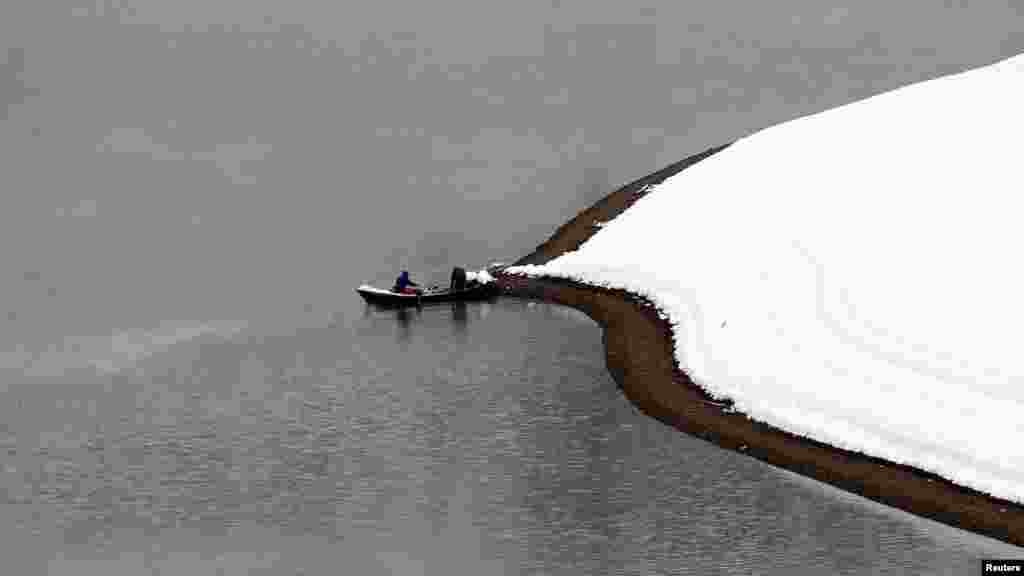 Two men fish on a lake after a snowfall near the Albanian city of Kukes, some 160 kilometers north of the capital, Tirana. (Reuters/Arben Celi)