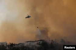 Vatrogasni helikopter ispušta vodu kako bi ugasio požar koji se približava naselju u blizini sela Cokertme u regiji Bodrum 3. avgusta 2021.