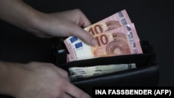Një person duke nxjerrë para nga kuleta. Fotografi ilustruese.