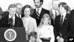 Președintele Jimmy Carter, însoțit de soția sa Rosalynn, fiica Amy și nepotul Jason, în timpul discursului prin care recunoștea victoria în alegeri a contracandidatului republican, Ronald Reagan. 4 noiembrie 1980.