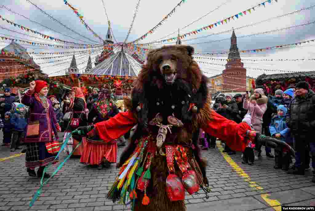 A performer wearing a mask dances and entertains the public near the Kremlin in Moscow on February 24.