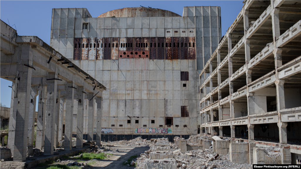 Вид из полуразрушенного здания машинного зала на здание энергоблока
