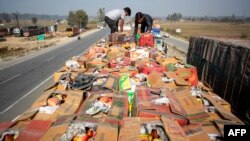 Men loads boxes of apples on a truck in the south of Kashmir on October 25. Four truck drivers have been killed in the past three weeks.