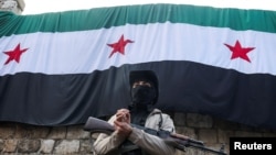 Боец Сил безопасности Сирии на страже перед новым измененным флагом страны на площади Баб-Тума в Дамаске. Осень 2025 года