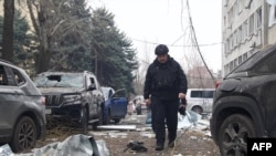 Mașini parcate în apropierea locului unde a căzut o rachetă, la Dnipro, pe 1 decembrie 2025. 