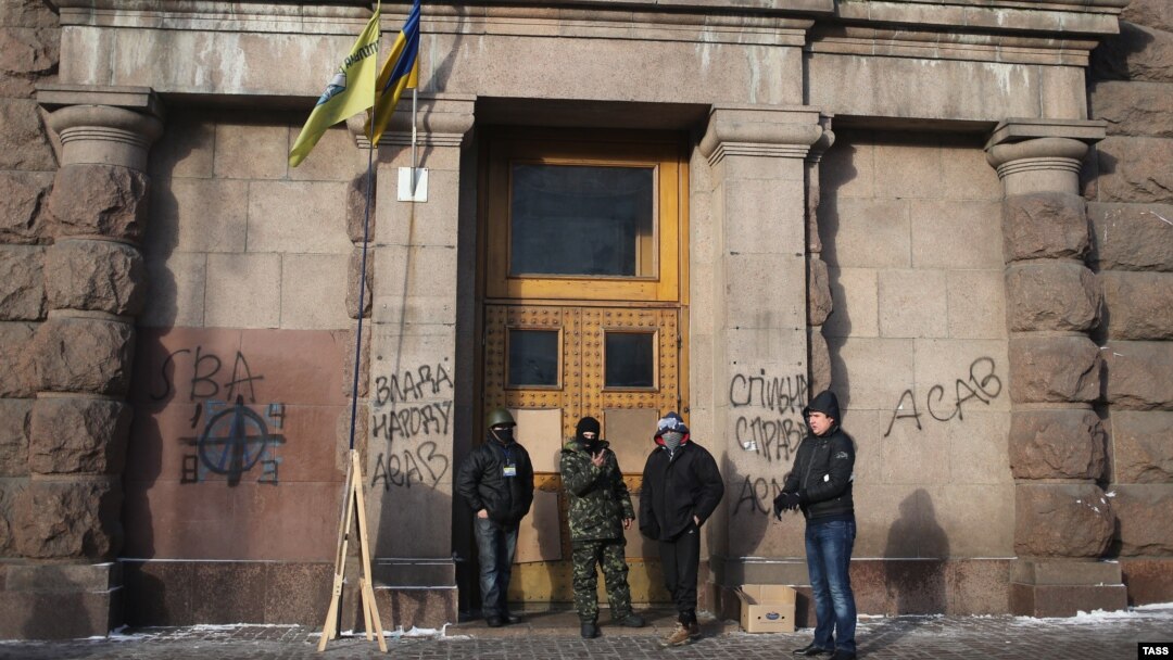 Ukrainian antigovernment protesters stand at the entrance of the Agricultural Ministry building in Kyiv which they occupied late last week. 