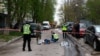 Police officers investigate next to bodies at the site of a shooting incident in Kyiv on April 18, 2026.