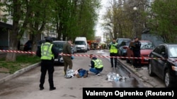 Police officers investigate next to bodies at the site of a shooting incident in Kyiv on April 18, 2026.