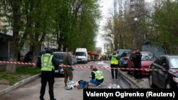 Поліцейські проводять розслідування поруч із тілами на місці стрілянини в Києві, 18 квітня 2026 року