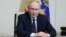 Russian President Vladimir Putin chairs a meeting with members of the Security Council via video link, outside Moscow