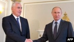 Russian President Vladimir Putin (right) shakes hands with the leader of Georgia's breakaway province of South Ossetia, Leonid Tibilov, during their meeting in Russia's Black Sea resort of Sochi in May 2013.