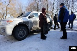 OSCE observers talk with a local resident in the flashpoint town of Avdiyivka on January 30.