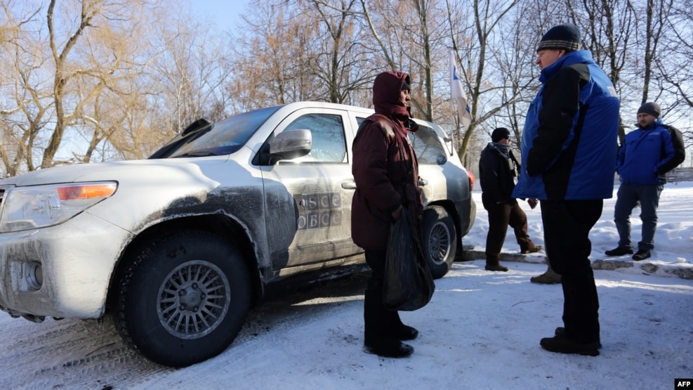 OSCE observers talk with a local resident in the flashpoint town of Avdiyivka on January 30.