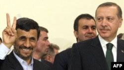 Iranian President Mahmud Ahmadinejad flashes the V-sign for victory as Turkish Prime Minister Recep Tayyip Erdogan looks on after Tehran signed a nuclear fuel-swap deal in Tehran on May 17.
