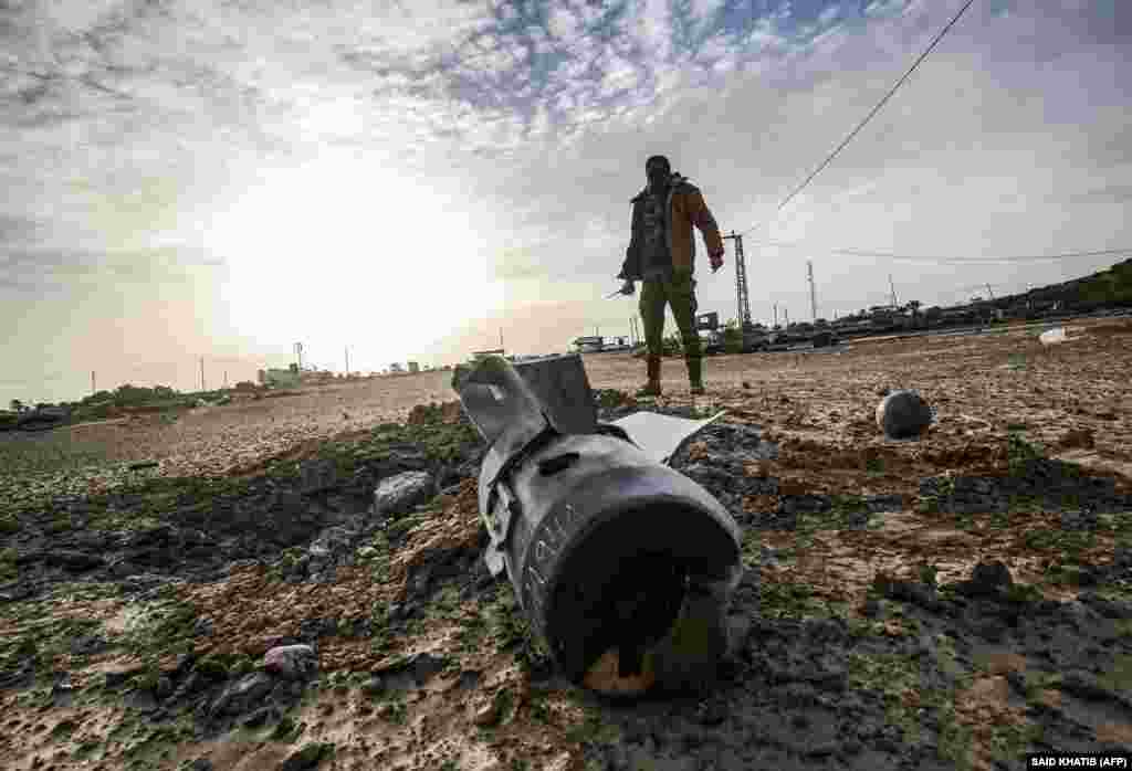 A Palestinian fighter from the Ezz-Al Din Al-Qassam Brigades, the armed wing of the Hamas movement, checks debris at the site of an Israeli air strike in Khan Yunis in the southern Gaza Strip December 26. (AFP/Said Khatib)​