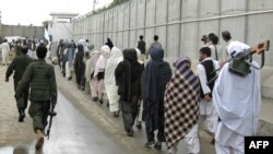 Taliban fighters peacefully surrender their arms during a meeting with Afghan government officials as part of the government's peace and reintegration process in Kandahar