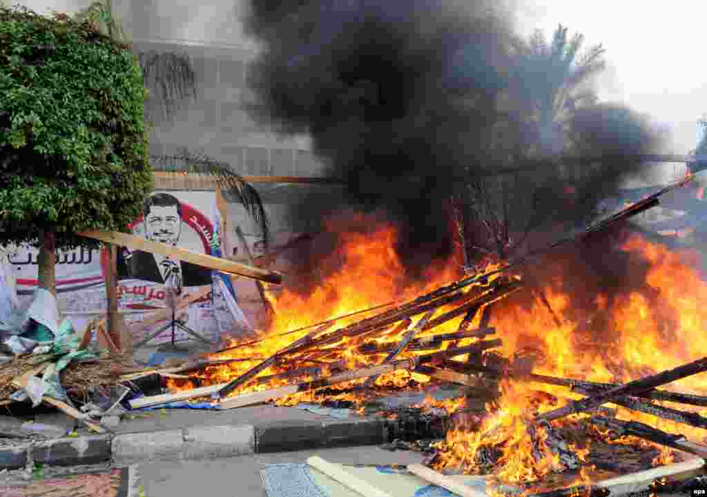 A tent burns as security forces clear the camp.