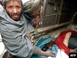 A mourner cries over the bodies of Afghan civilians massacred by U.S. Army Staff Sergeant Robert Bales on March 11, 2012.