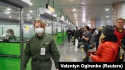 Grănicer ucrainean verificând călătorii întorși din China