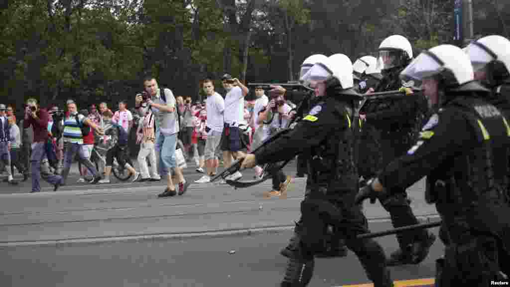 Polish riot police shoot rubber bullets during clashes with soccer fans before the match between Poland and Russia in Warsaw.