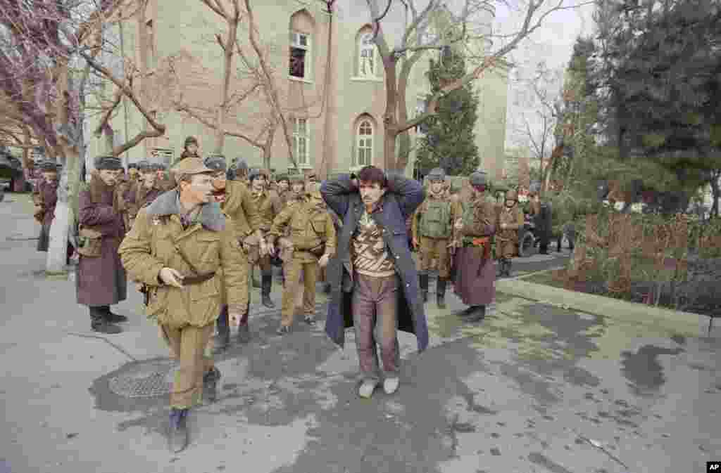 Soviet troops surround a resident of Baku on January 22 during one of their patrols through the Azerbaijani capital.